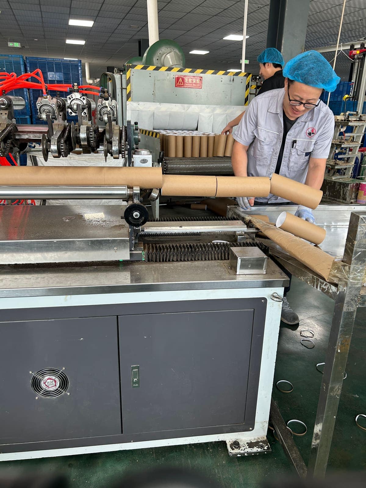 Operator running a paper tube winding machine on the production line