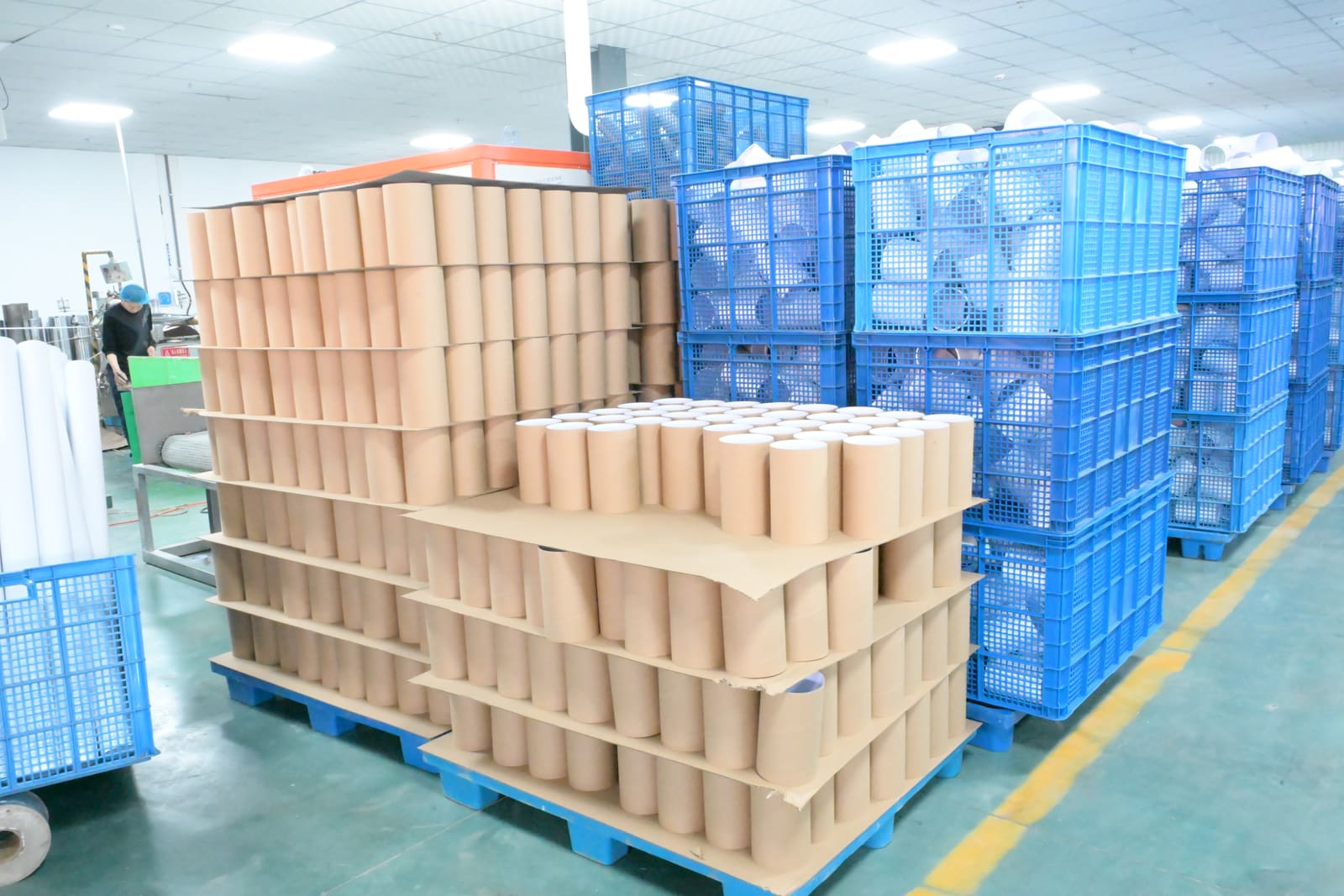 Production floor with stacked kraft paper tubes awaiting finishing